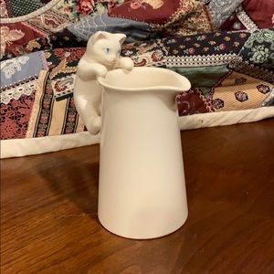 Kitten climbing pitcher of cream